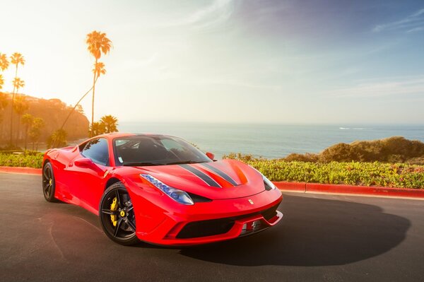 Ferrari rojo contra las nubes y el océano