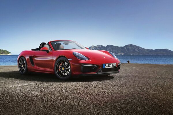 Porsche rouge sur fond de montagnes