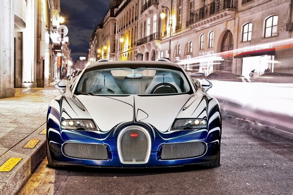 Bugatti de lujo y luces de la ciudad de la noche