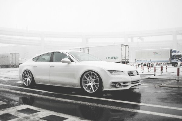 Retro photo in black and white with a white Audi on the street