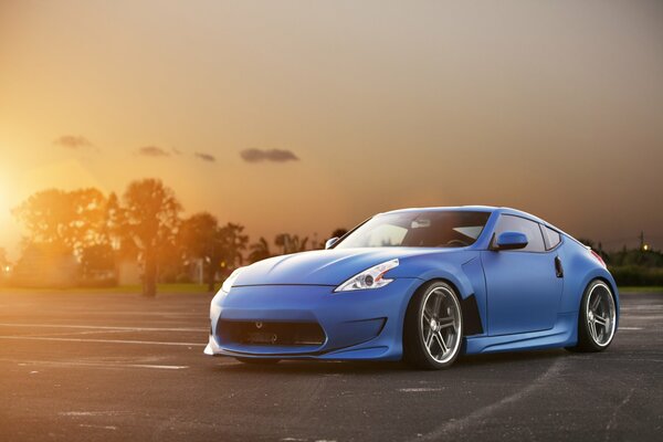 Blue car on sunset background