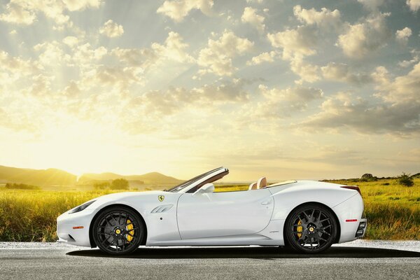 White Ferrari on the background of the rising sun, blue sky in the fields of California