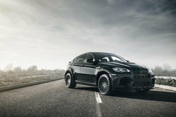 Schwarzer bmw x6m fährt auf der Straße