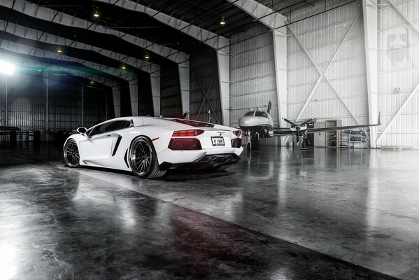 Lamborghini blanco en el hangar de aviones