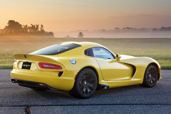 Voiture de sport au beau coucher de soleil