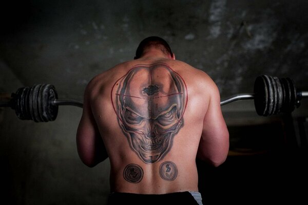 Tatuaje en la espalda de un atleta en forma de cráneo