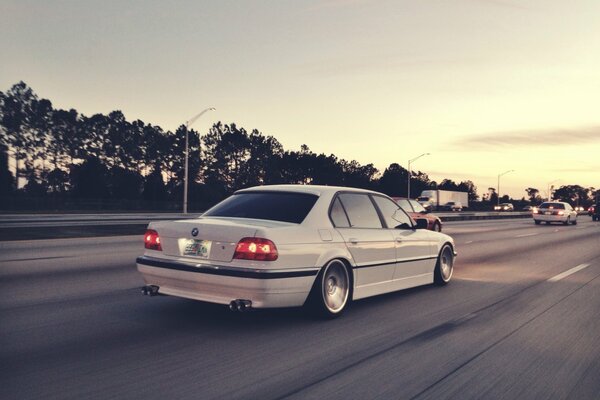 La BMW E38 bianca corre a velocità autostradale