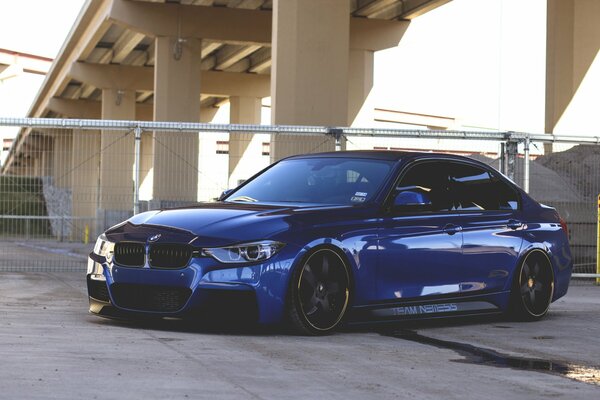 BMW azul en la ciudad bajo el paso elevado