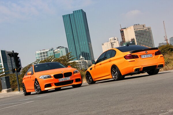 Two orange BMWs on against each other
