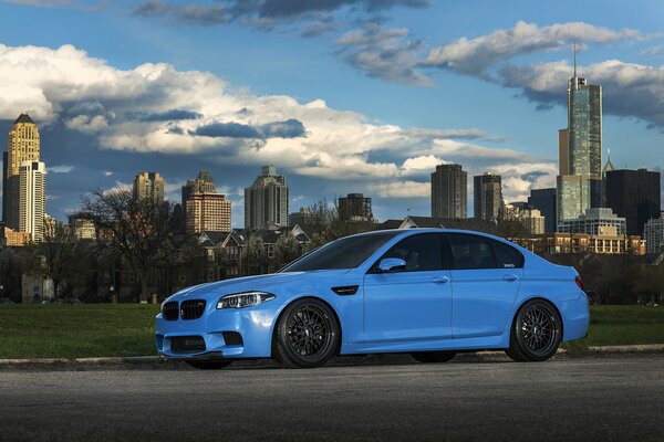 Blue bmw on the background of a skyscraper