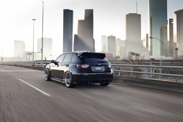 The beauty of the city among which is a black Subaru