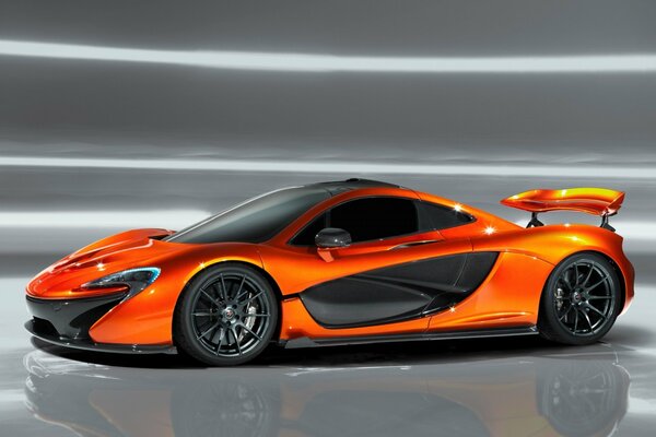 In mostra, la supercar arancione McLaren con contorni aggressivi e spoiler posteriore