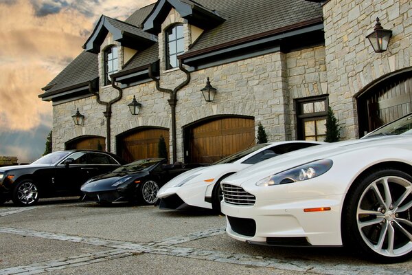 Cool cars of different brands are parked on the street near the house