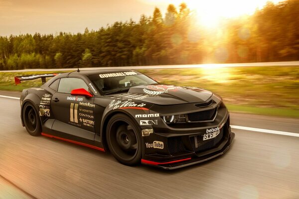 Hermoso coche en la pista en una puesta de sol