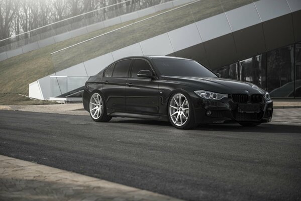 Bmw 335i черного цвета стоит на дороге