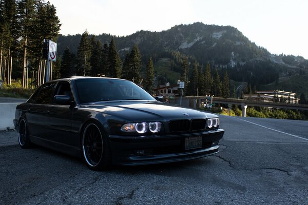 BMW noir sur la route sur fond de montagnes