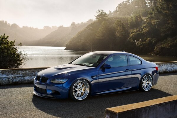 Blauer BMW auf der Brücke über den Fluss