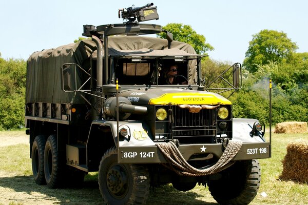 Großer Militär-LKW mit Fahrer auf dem Hintergrund der grünen Bäume