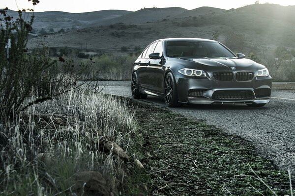 BMW noire dans un virage au bord de la route