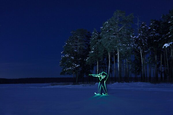 Sylwetka biathlonisty na tle zimowych drzew