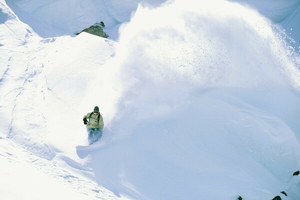 A snowboarder stands against the background of snow