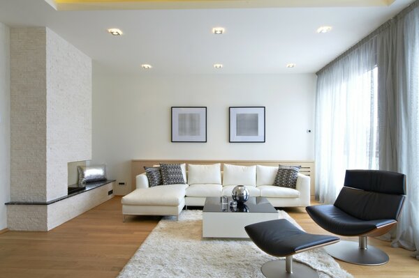 Studio apartment with a large white sofa and black chairs