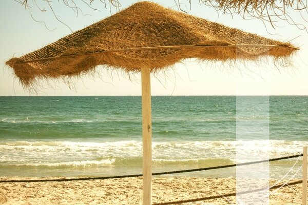 Ombrello di paglia sullo sfondo della spiaggia