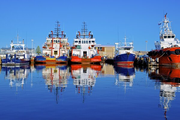 Schiffe, die im Wasser reflektiert werden, werden am australischen Hafen festgemacht