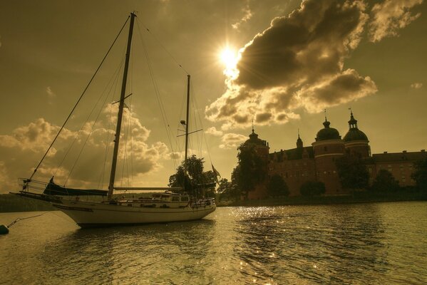 Yacht vor dem Hintergrund des Sonnenuntergangs am Schloss