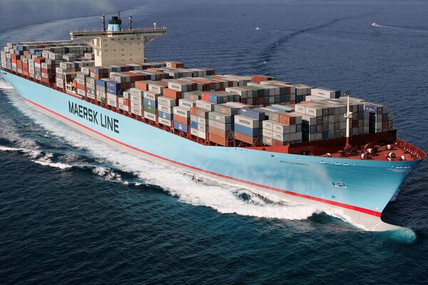 Ein riesiges Containerschiff schwimmt über das blaue Meer