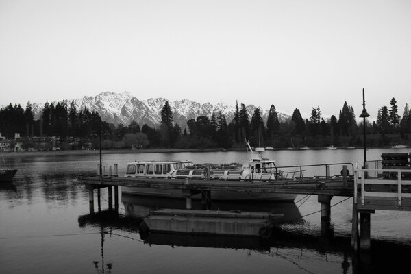 Black and white photo of a boat on the background of mountains