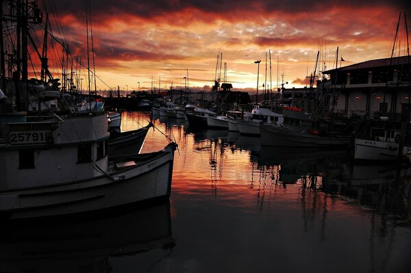 There is a pier for ships in the harbor at a picturesque sunset