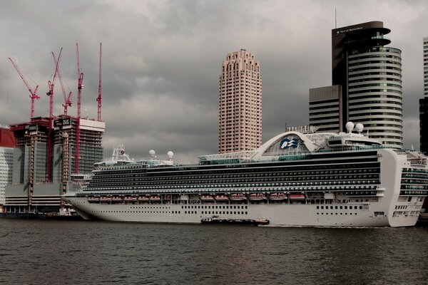 Liner at the pier on the background of buildings under construction, Rotterdam