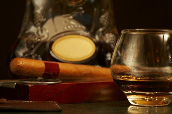 A glass of cognac with a cigar in the bar