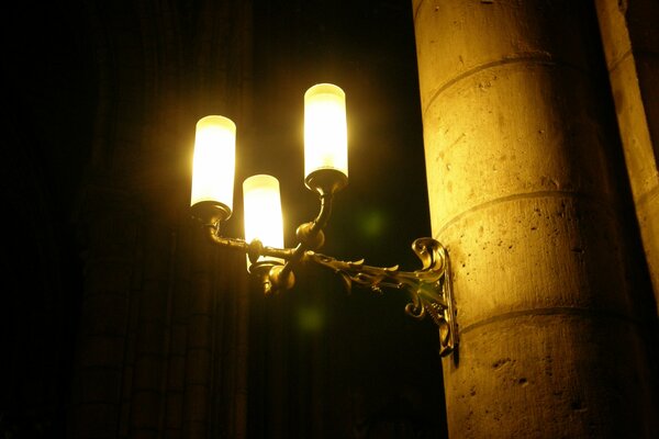 Lanterne sur un pilier dans une ruelle sombre