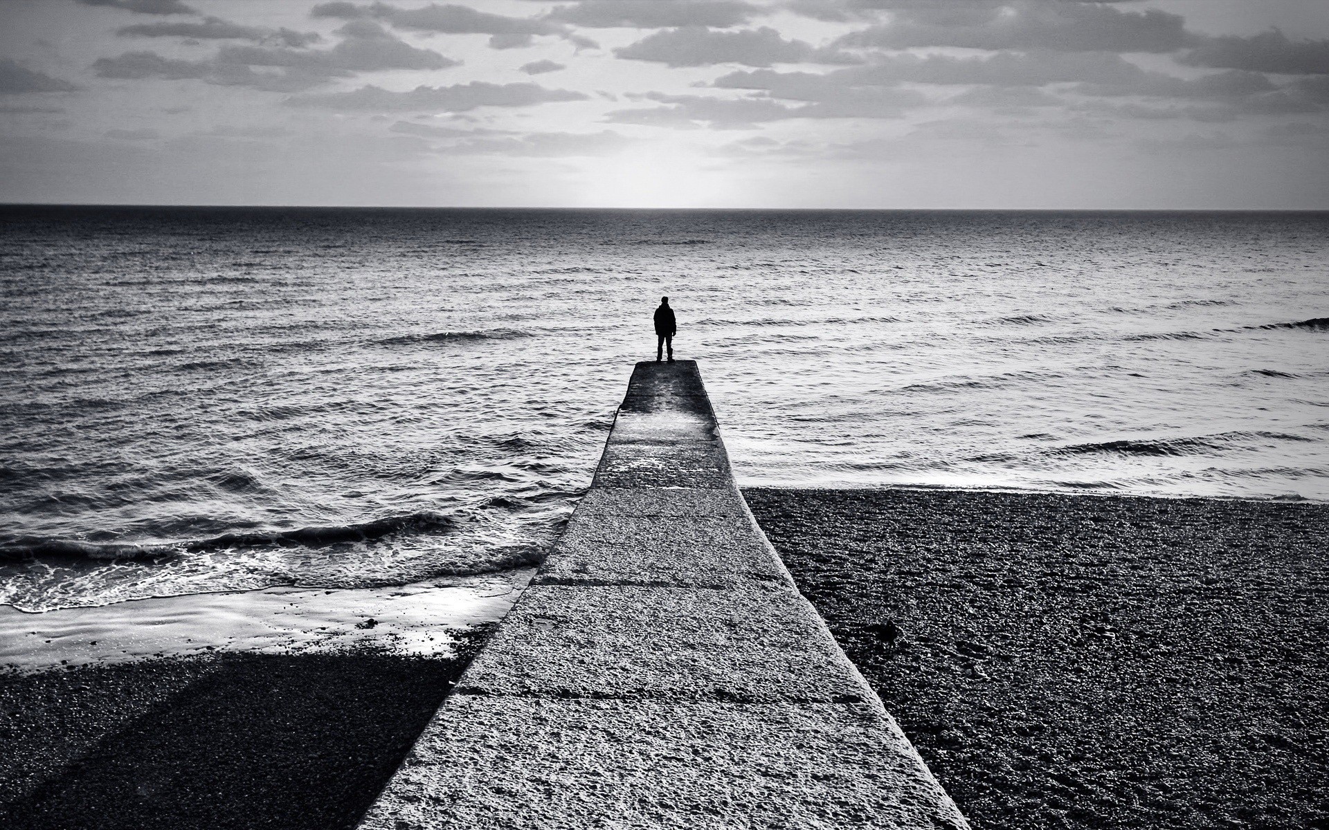 noir et blanc horizon homme quai côte mer