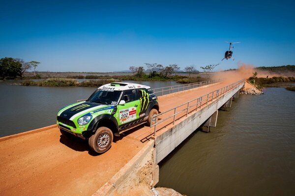 Racing bridge desert helicopter river dust cloud