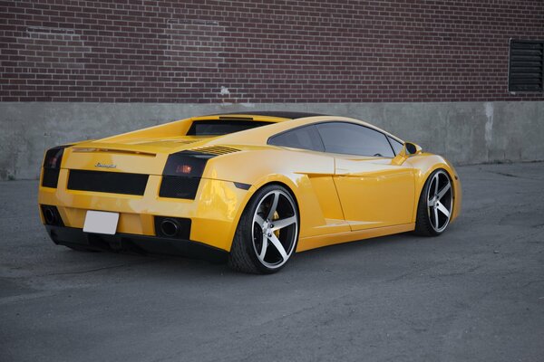 Czerwona cegła na tle żółtego Lamborghini