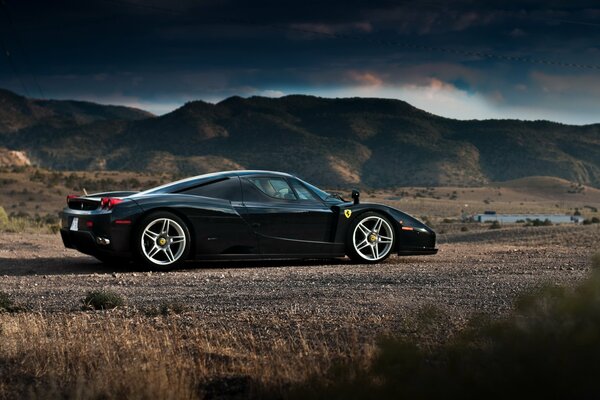 Black ferrari enzo on the background of mountains