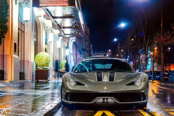 Die Straße von Paris nach dem Regen. Ein Ferrari-Auto auf einer nächtlichen Straße