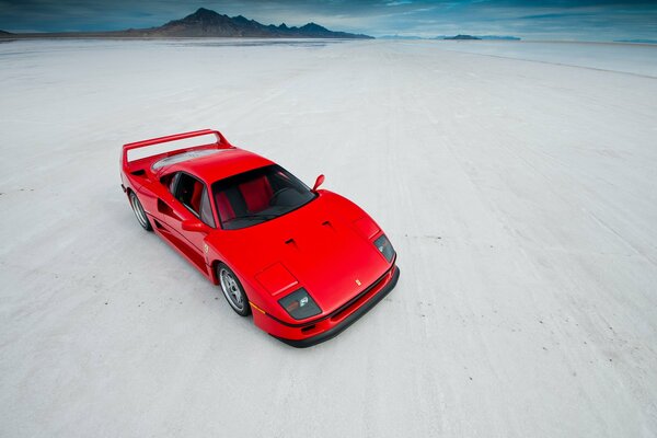 Roter Ferrari auf weißem Sand