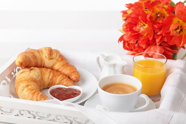 Frühstück im Bett mit Croissants und Marmelade