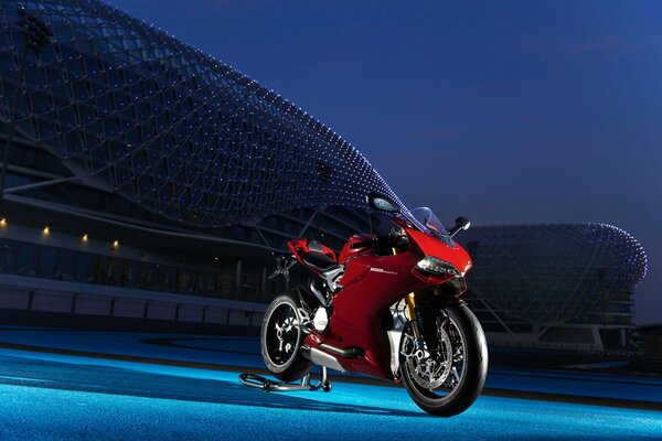 Sportbike Ducati de color rojo en el estadio nocturno