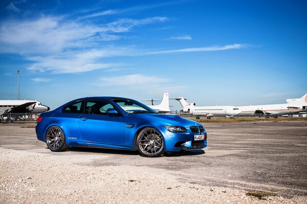 BMW azul en la pista de aeródromo