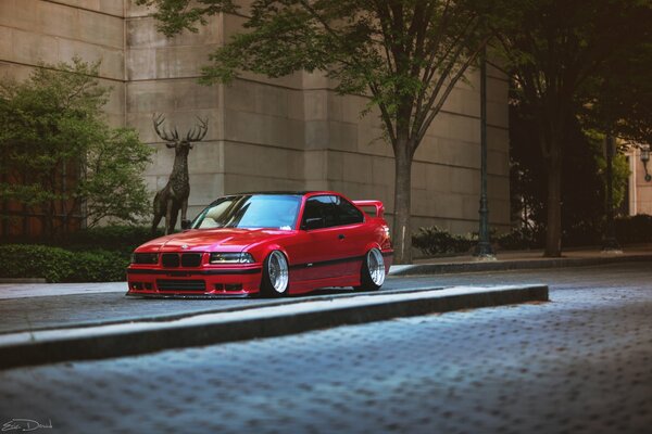 Bmw E36 rojo en el fondo del edificio