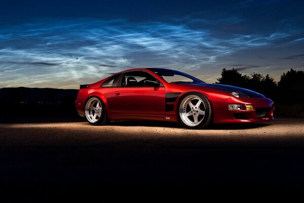 Side view of a red Nissan car