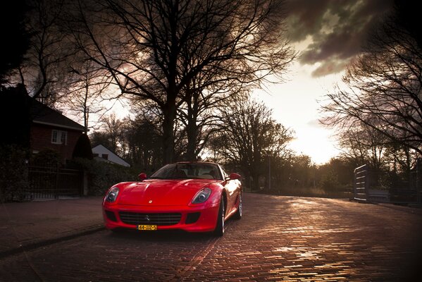 Auf der Herbststraße ein roter Ferrari-Sportwagen