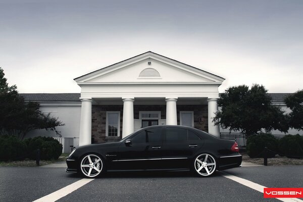 Black mercedes benz on the background of a beautiful house