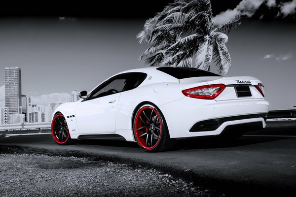 Maserati granturismo na wjeździe do pochmurnego miasta