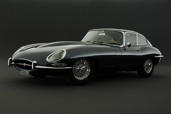 Retro foto di auto nera Jaguar su sfondo nero